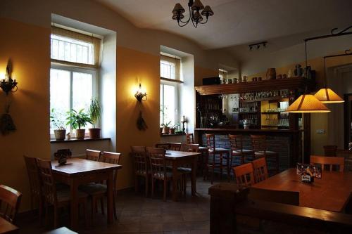 restauracja z drewnianymi stołami, krzesłami i oknami w obiekcie Saraya Wellness & Penzion w Cieplicach