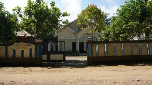 a gate in front of a house with a fence at Hotel O Homestay Srikandi Pulau Merah BeachNearPantai Pancer in Pasanggaran