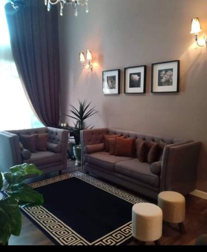 a living room with a couch and two chairs at Tiara Homestay in Kuantan