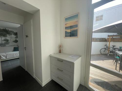 Cette chambre comprend une commode et une porte donnant sur un balcon. dans l'établissement Triplex calme avec terrasse, climatisation, proche plage et commerces à Arcachon - FR-1-474-249, à Arcachon
