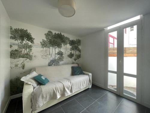 d'un salon avec un canapé orné d'une peinture murale. dans l'établissement Triplex calme avec terrasse, climatisation, proche plage et commerces à Arcachon - FR-1-474-249, à Arcachon