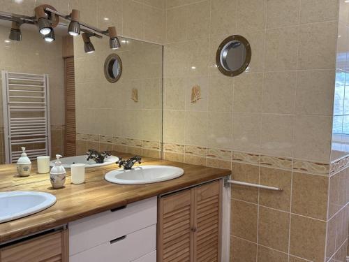a bathroom with two sinks and a large mirror at Gîte Laprugne, 4 pièces, 6 personnes - FR-1-489-458 in Laprugne