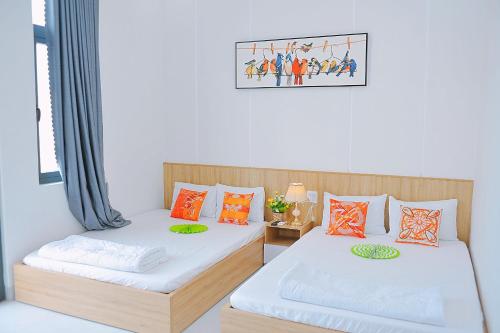 2 Betten nebeneinander in einem Zimmer in der Unterkunft Khách Sạn Toàn Yến - Nhơn Lý in Hưng Lương
