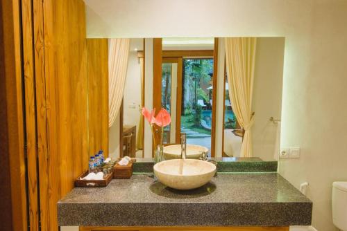 Taman Amartha Hotel في أوبود: حمام مع حوض على منضدة