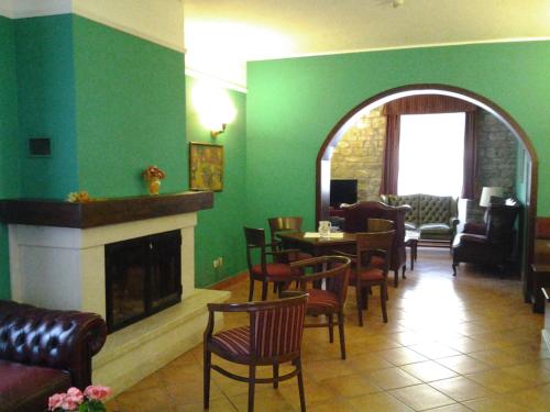 a living room with a fireplace and a table and chairs at Casale Maginulfo in Roccamandolfi