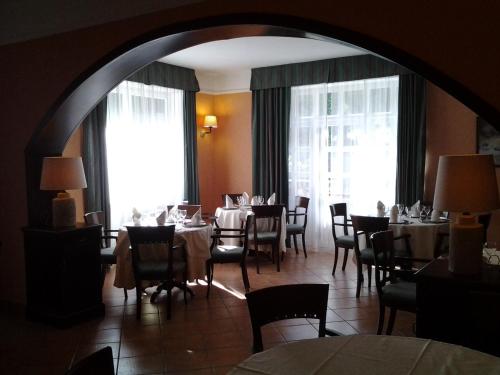 a dining room with tables and chairs and large windows at Casale Maginulfo in Roccamandolfi