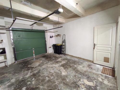 a garage with a green chalkboard and a door at Historical center 3 st house, garage & tropeziene in Pézenas