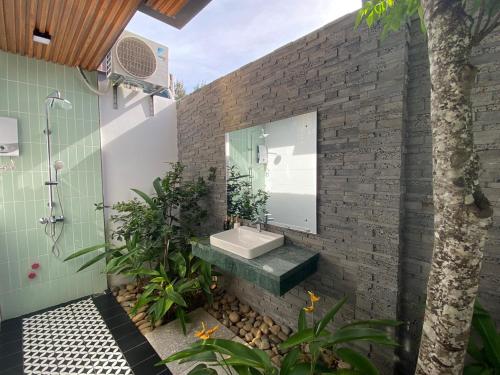 La salle de bains est pourvue d'un lavabo et d'un mur en briques. dans l'établissement Villa Container, à Vung Tau