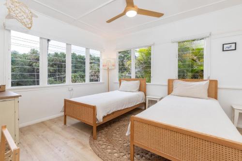 two beds in a room with windows at Trade Winds in Elizabeth Beach