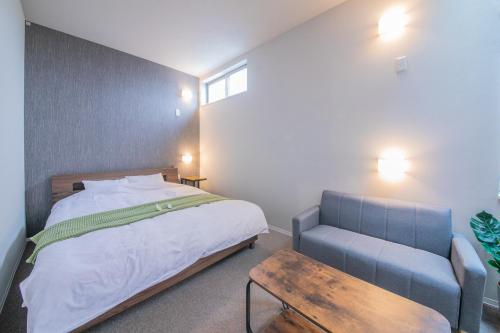 a bedroom with a bed and a bench in it at KIZUNA HOTEL Gojo Kiyomizu-dera Kamogawa in Kyoto