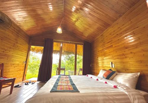 a bedroom with a large bed in a wooden room at Bac Ha Lodge Retreat in Bắc Hà