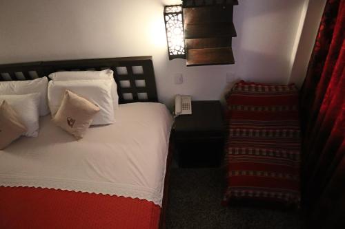 a bedroom with a bed with white sheets and pillows at Cusco Bed and Breakfast in Cusco