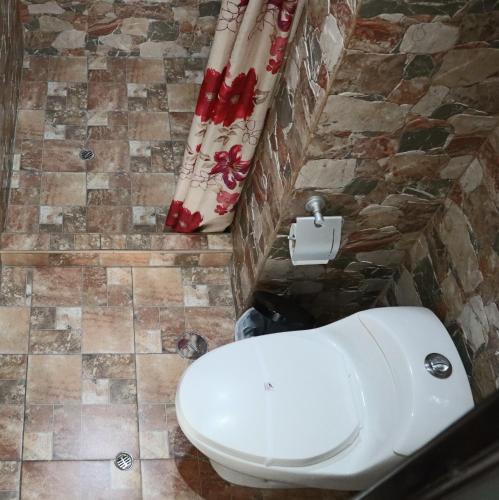 a bathroom with a white toilet in a room at Cusco Bed and Breakfast in Cusco