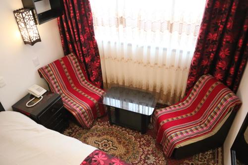 a hotel room with two chairs and a window at Cusco Bed and Breakfast in Cusco
