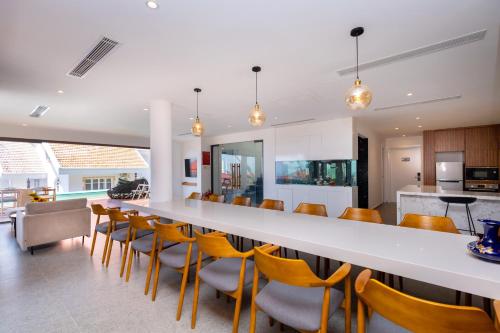 a kitchen and dining room with a long table and chairs at Cosa villages in Vung Tau