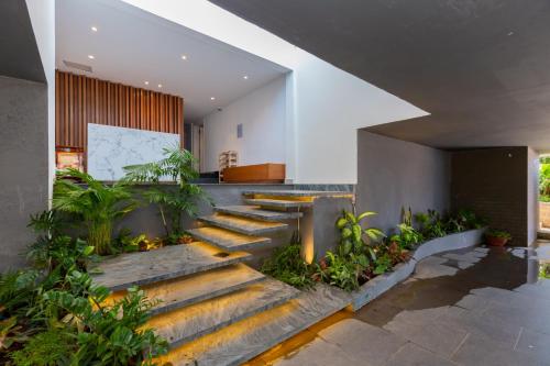 a lobby with stairs and plants in a building at Cosa villages in Vung Tau