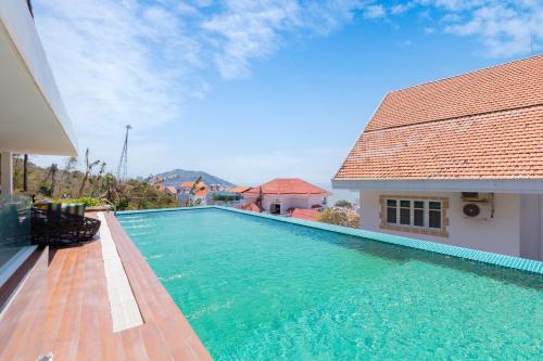 a swimming pool next to a house with a building at Cosa villages in Vung Tau