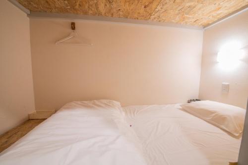 a white bed in a room with a ceiling at KIZUNA HOTEL Gojo Kiyomizu-dera Kamogawa in Kyoto