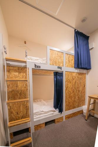 a room with two bunk beds with blue curtains at KIZUNA HOTEL Gojo Kiyomizu-dera Kamogawa in Kyoto