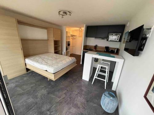 Cette petite chambre comprend un lit et une cuisine. dans l'établissement STUDIO VUE MER LE FORT BLOQUE PLOEMEUR, à Ploemeur