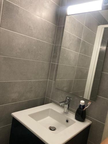 une salle de bain avec un lavabo et un miroir dans l'établissement STUDIO VUE MER LE FORT BLOQUE PLOEMEUR, à Ploemeur