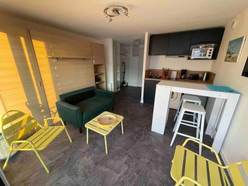 un salon avec un canapé, une table et des chaises dans l'établissement STUDIO VUE MER LE FORT BLOQUE PLOEMEUR, à Ploemeur