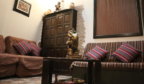 a living room with a couch and a statue on a table at Cusco Bed and Breakfast in Cusco