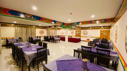 a restaurant with purple tables and chairs in a room at hotel palam hills in Leh
