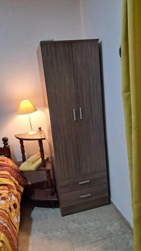 a bedroom with a large wooden cabinet next to a bed at centrico pb "A" in Resistencia