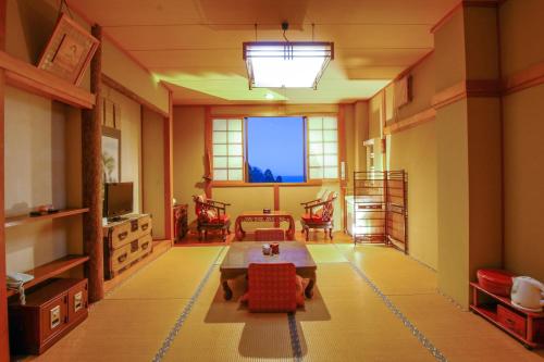 日立的住宿－Oshironoyado Hanaguruma，客厅配有桌子和一些椅子