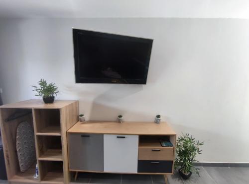 ein Wohnzimmer mit einem TV an einer weißen Wand in der Unterkunft Grey Diamond Studio in Le Diamant