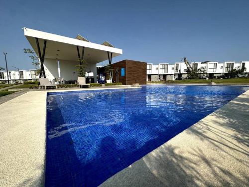 a large blue swimming pool in front of a building at Modern Beautiful Condo in Mezcales