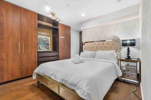 a bedroom with a large white bed and wooden cabinets at Home*walking Chadstone shopping centre in Chadstone