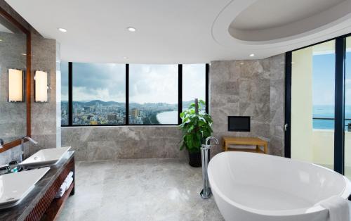 a bathroom with a tub and a large window at Four Points by Sheraton Hainan, Sanya in Sanya