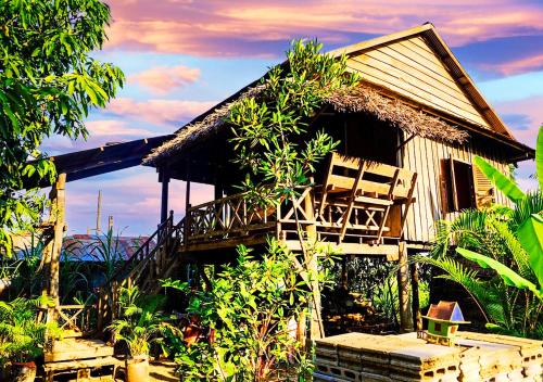 une maison avec 2 chaises sur la terrasse couverte dans l'établissement Family Batcave Homestay, à Battambang