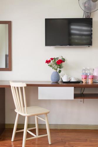 a desk with a chair and a television on a wall at Tasme Hotel in Da Lat