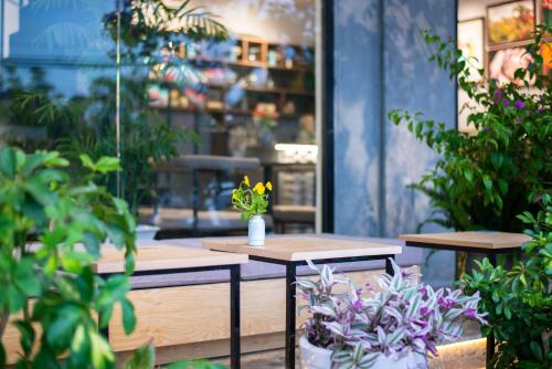 a patio with tables and plants in a store at Tasme Hotel in Da Lat
