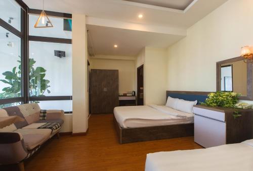 a hotel room with a bed and a couch at Tasme Hotel in Da Lat