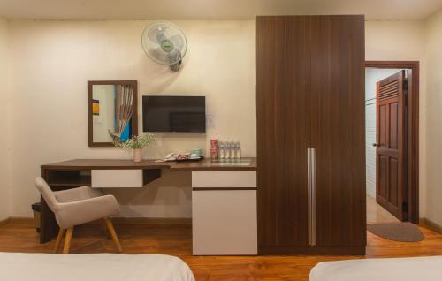 a room with a desk with a computer and a mirror at Tasme Hotel in Da Lat