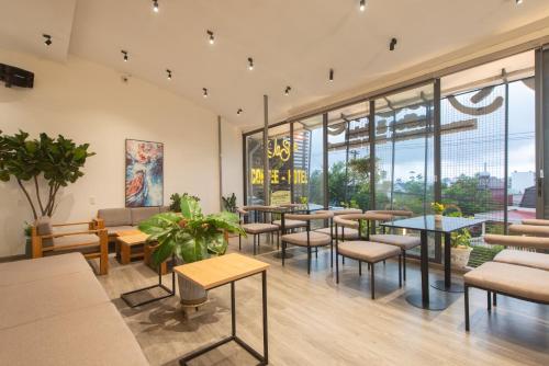 a restaurant with tables and chairs and windows at Tasme Hotel in Da Lat