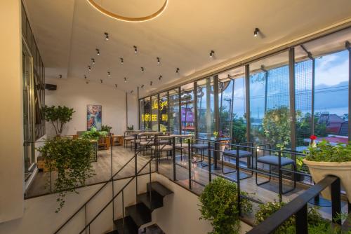 a restaurant with a balcony with tables and chairs at Tasme Hotel in Da Lat