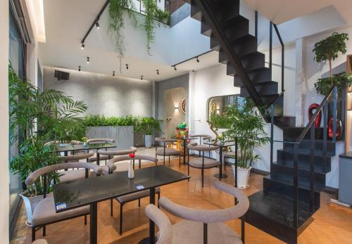 a restaurant with tables and chairs and potted plants at Tasme Hotel in Da Lat