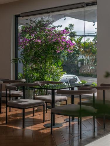 a room with tables and chairs and a plant with purple flowers at Tasme Hotel in Da Lat