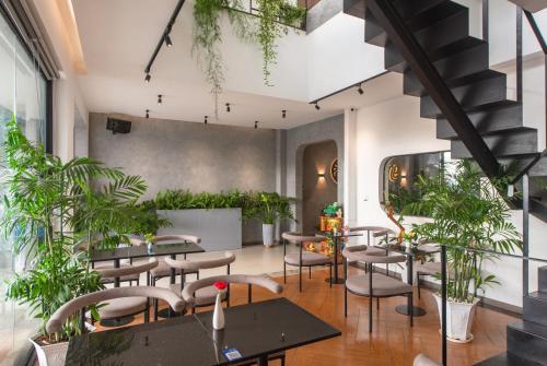a restaurant with tables and chairs and potted plants at Tasme Hotel in Da Lat
