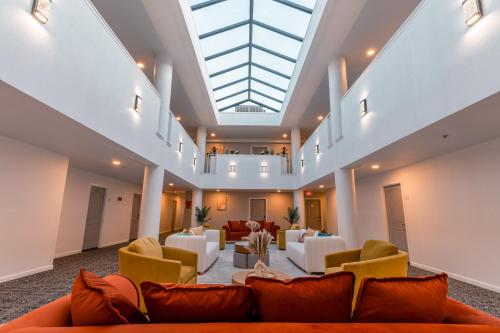 a large lobby with couches and chairs and a skylight at Hotel Aluxor SFO, Shuttle Service in San Bruno