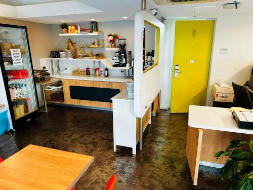 a kitchen with a counter and a yellow door at ibis Budget Wentworthville in Wentworthville