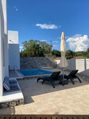 een patio met 2 stoelen, een parasol en een zwembad bij Casa Christiana, Lardos in Lardos