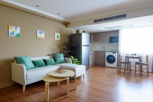 a living room with a couch and a table at SC Park Hotel in Bangkok