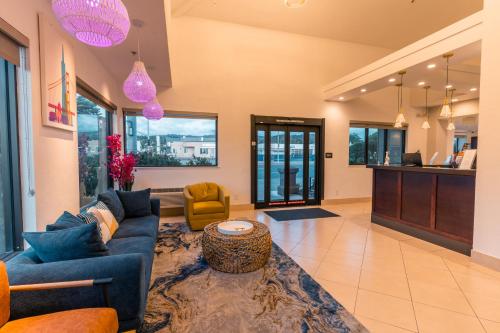 a living room with a blue couch and a table at Hotel Aluxor SFO, Shuttle Service in San Bruno