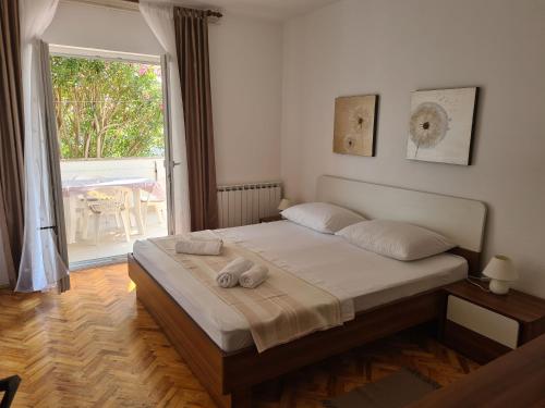 a bedroom with a bed and a large window at Apartments Ivo in Pag